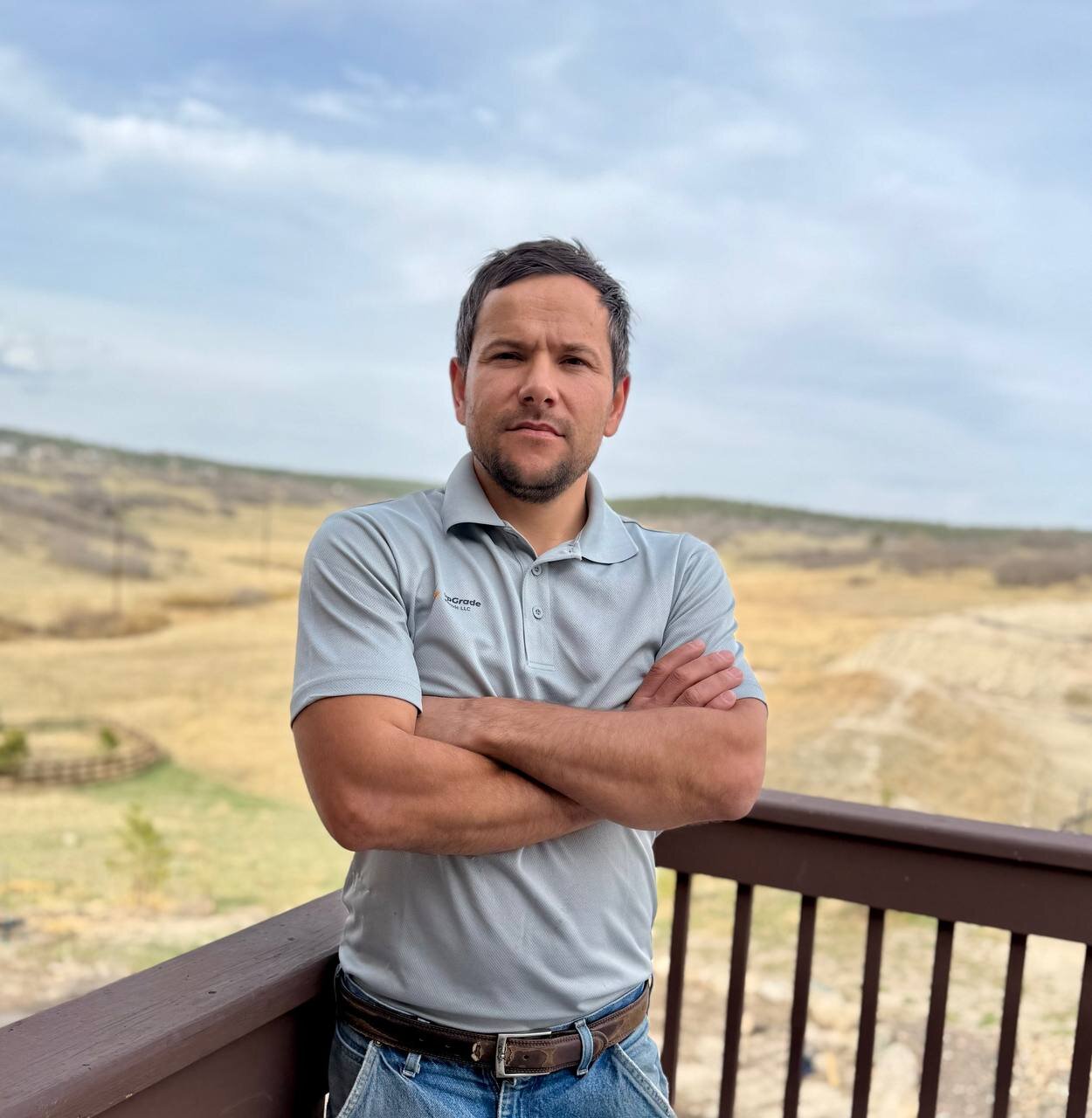 Sergii Smitiukh, Owner of upGrade electric, standing on a deck with Colorado Front Range in the background