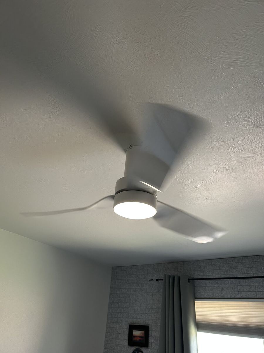 Modern dark wood ceiling fan with light kit installed on shiplap ceiling