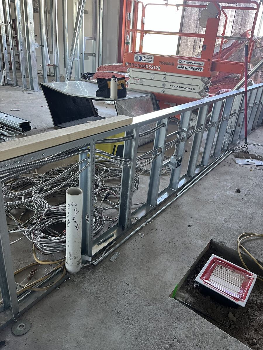 Multiple flexible conduit runs through stud framing in commercial space