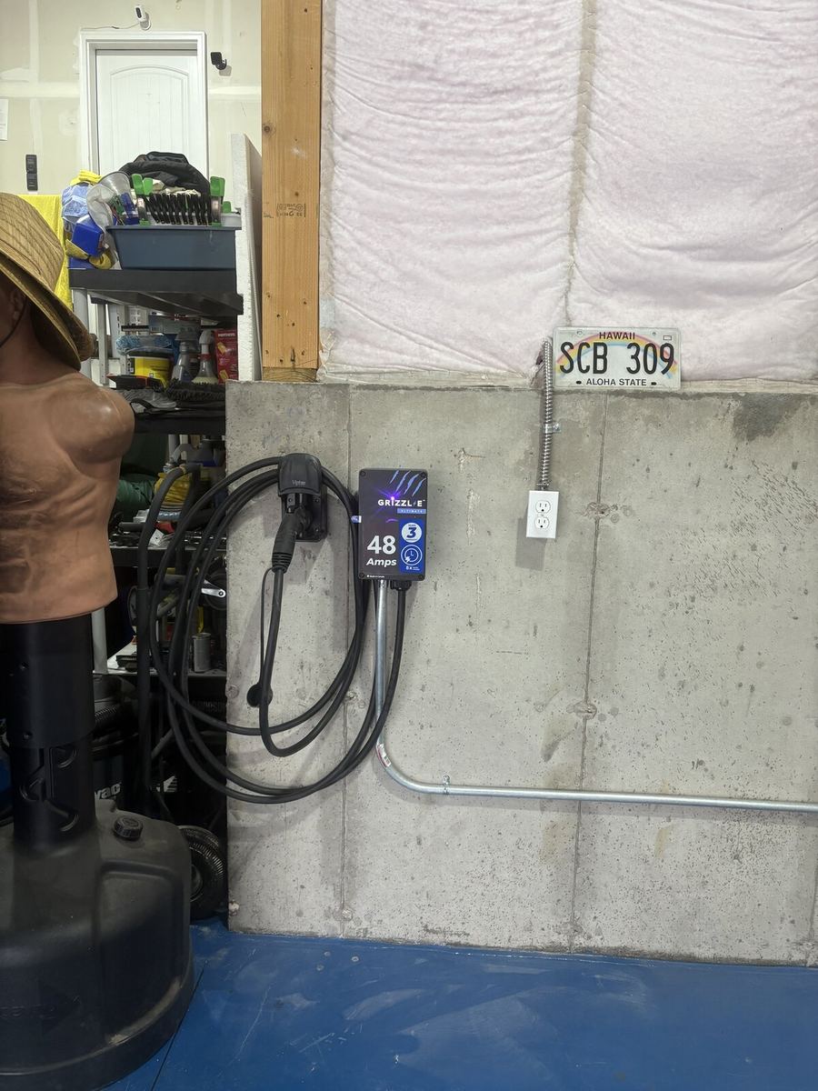 Tesla Wall Connector with cable wrap on residential garage wall