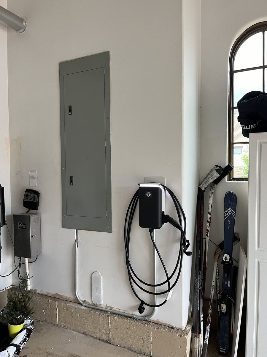 Tesla EV charger installed next to garage panel