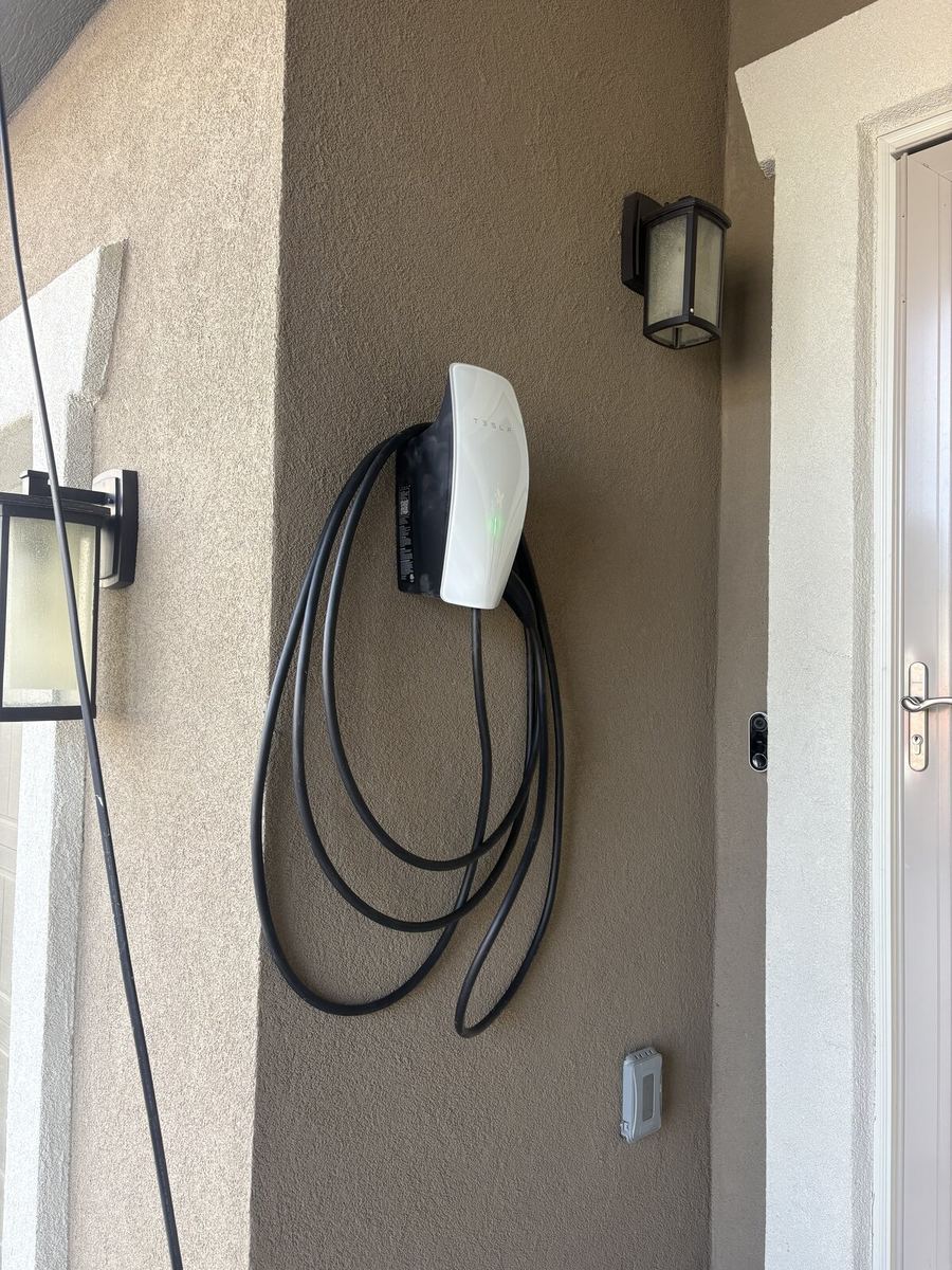 Tesla Wall Connector mounted on exterior stucco wall