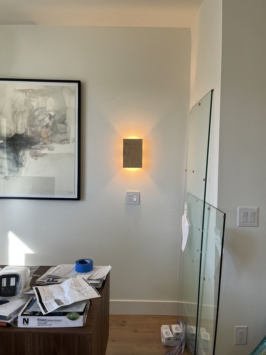 Three-bulb glass vanity light installed above a bathroom mirror