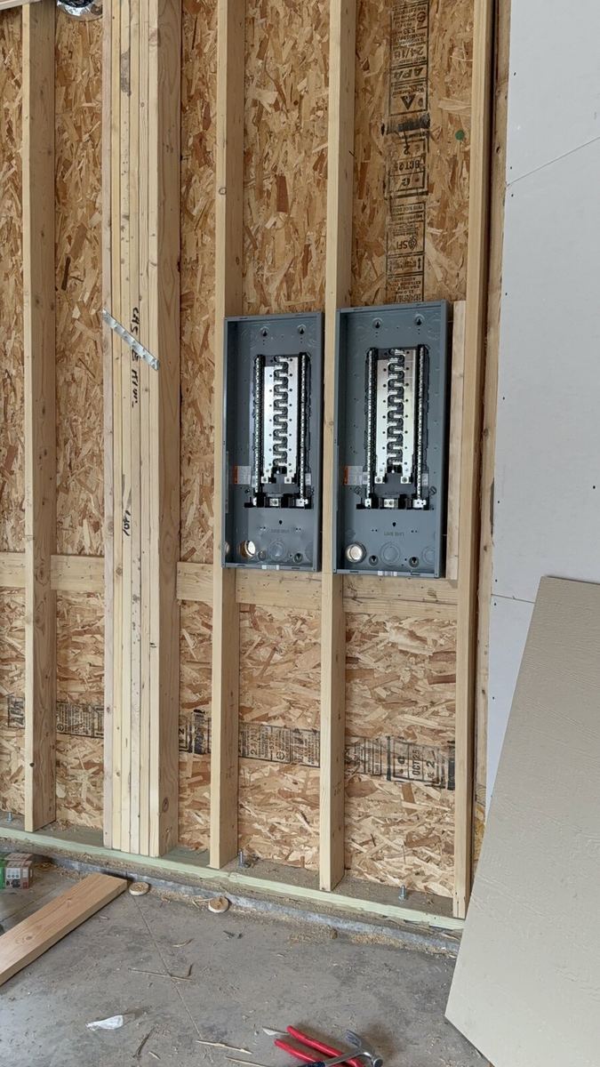 Dual breaker panels installed on OSB framing during new construction