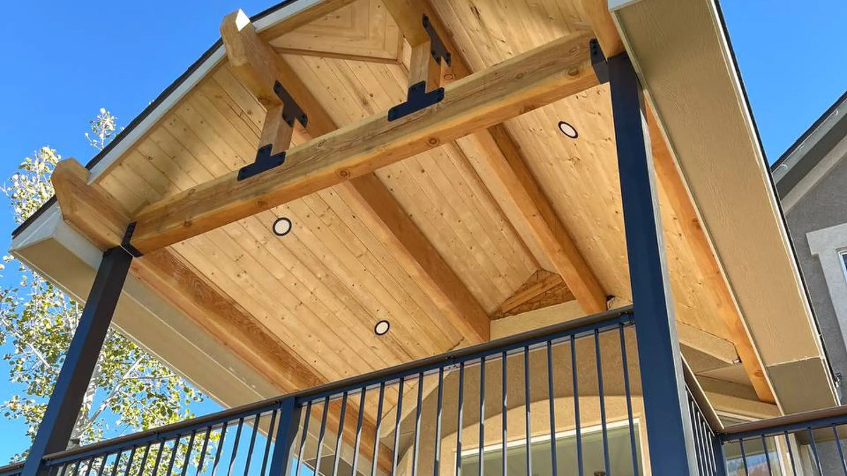 Recessed accent lights in a covered patio cedar ceiling against blue sky
