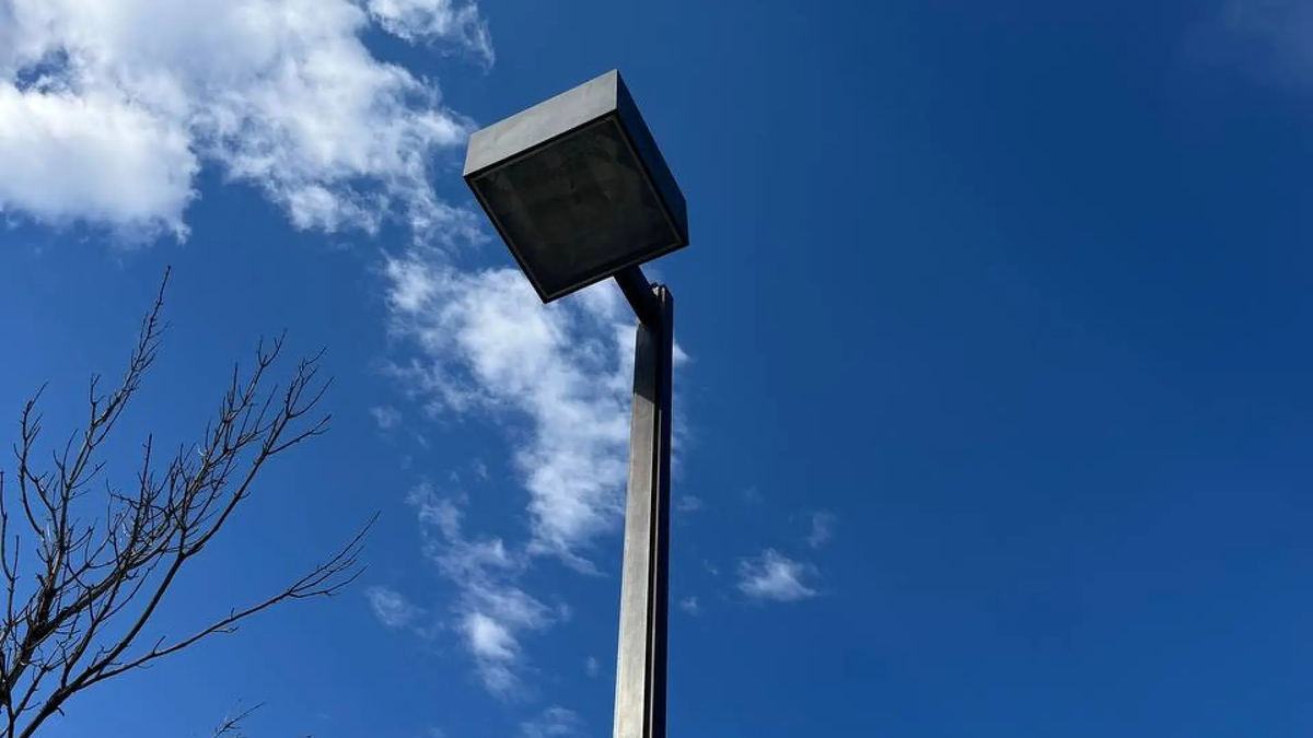 Commercial parking lot pole light against a clear blue sky