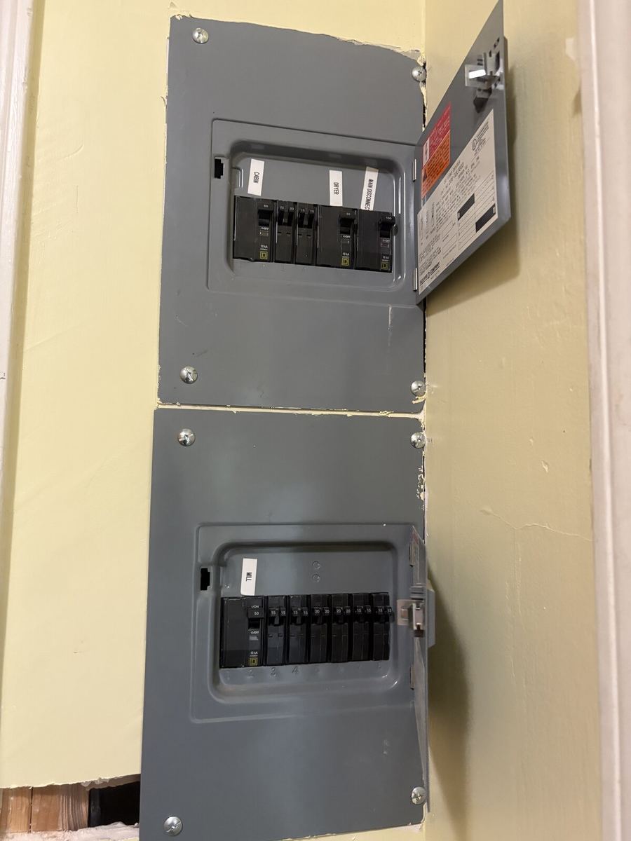 Dual load center installed inside garage with labeled breakers